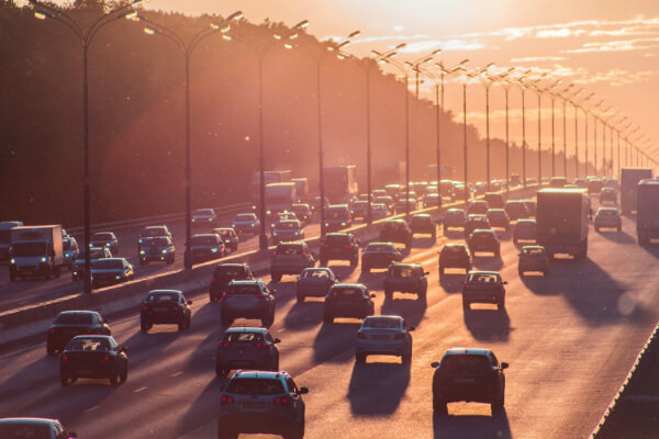 Imagen en la que se muestra una gran multitud de coches en una vía fuera de ciudad.